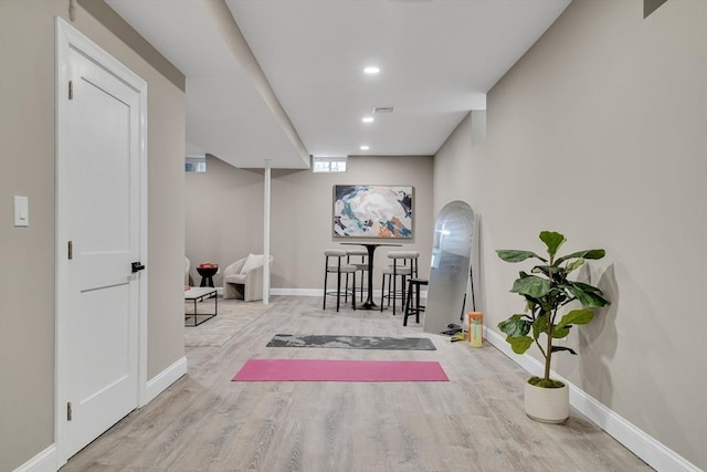 exercise room with light hardwood / wood-style flooring