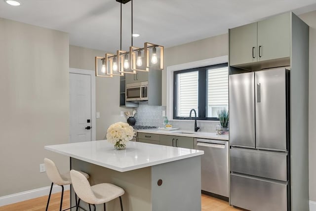 kitchen with sink, light wood-type flooring, a center island, and appliances with stainless steel finishes