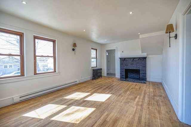 unfurnished living room with recessed lighting, wood finished floors, baseboards, and a baseboard radiator