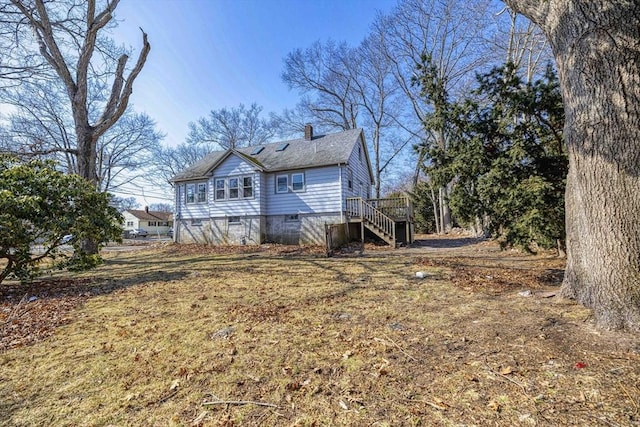 view of property exterior featuring stairs, a shingled roof, and a chimney