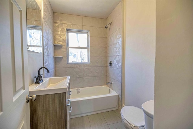 bathroom featuring tile patterned flooring, toilet, vanity, and  shower combination