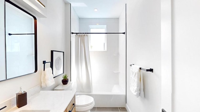 bathroom featuring toilet, vanity, shower / bath combo with shower curtain, and tile patterned floors