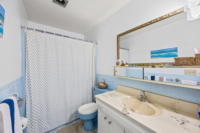 bathroom with curtained shower, tile walls, toilet, and vanity