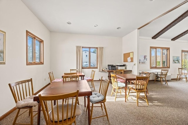 carpeted dining room with beamed ceiling