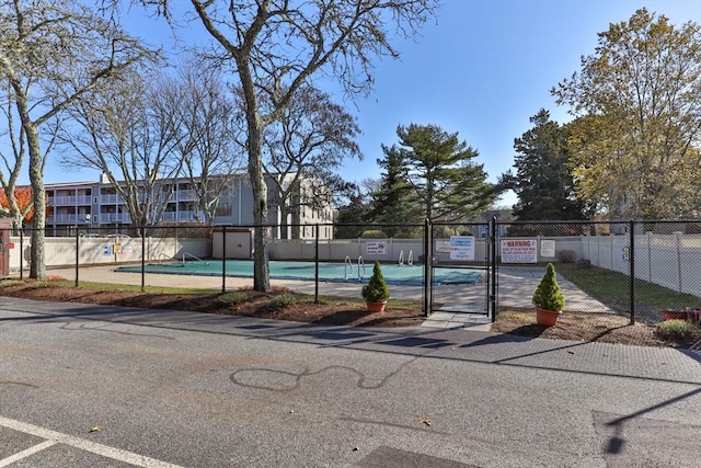 view of swimming pool with tennis court