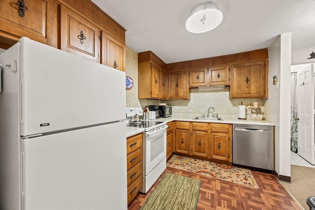 kitchen with sink, white appliances, and dark parquet floors