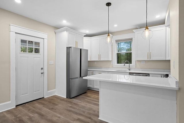 129 S Main St, Raynham, MA 02767 - kitchen with appliances with stainless steel finishes, a sink, white cabinets, light countertops, and a peninsula