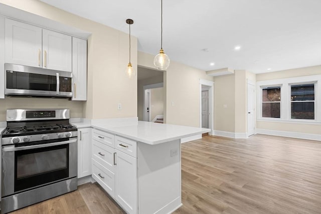 129 S Main St, Raynham, MA 02767 - kitchen with stainless steel appliances, a peninsula, light countertops, light wood finished floors, and open floor plan