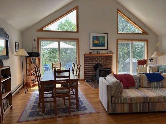 190 Longview Rd, West Tisbury, MA 02575 - dining room featuring plenty of natural light, a wood stove, high vaulted ceiling, wood finished floors, and a baseboard heating unit