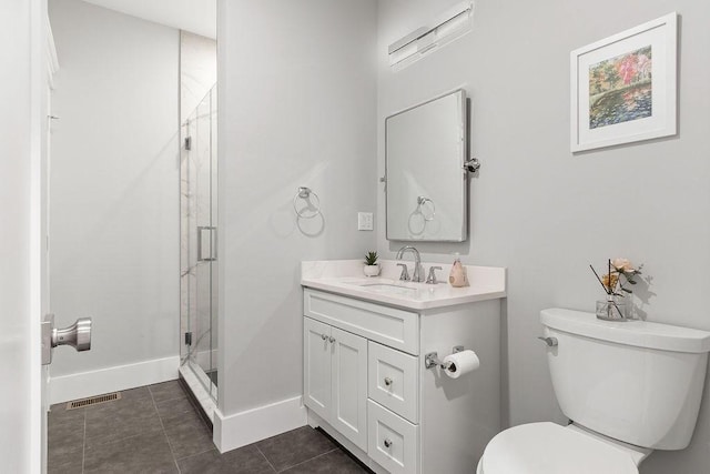 bathroom with toilet, a shower stall, vanity, tile patterned flooring, and baseboards