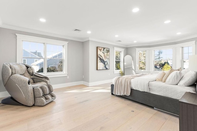 bedroom with light wood finished floors, multiple windows, and crown molding