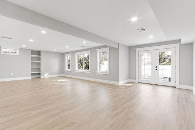 unfurnished living room with french doors, light wood-style flooring, plenty of natural light, and visible vents