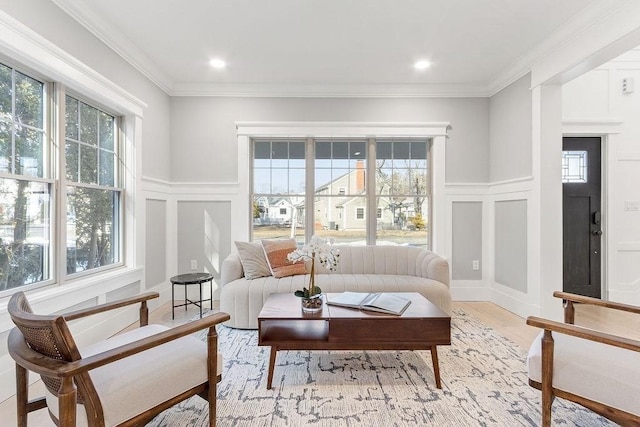 living room featuring crown molding, light wood finished floors, recessed lighting, and a decorative wall