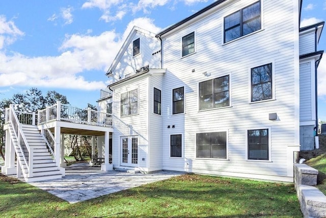 back of house featuring a patio, a lawn, a wooden deck, and stairs