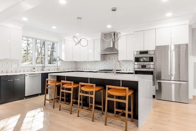 kitchen featuring modern cabinets, stainless steel appliances, light countertops, and a kitchen breakfast bar