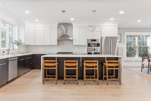 kitchen with stainless steel appliances, modern cabinets, decorative light fixtures, and white cabinets