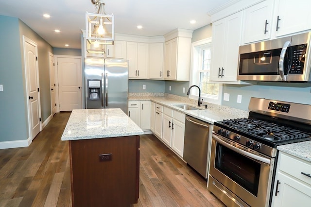 kitchen featuring white cabinets, sink, a kitchen island, and appliances with stainless steel finishes