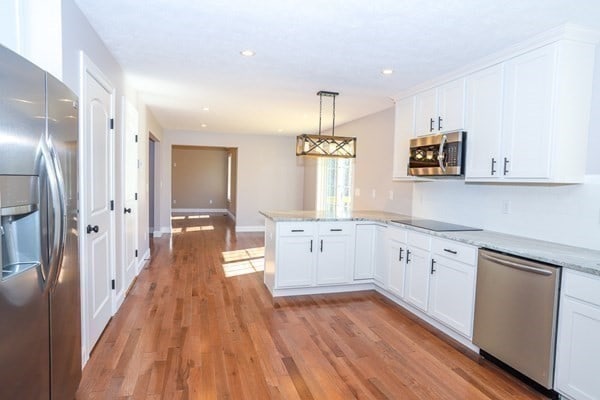 kitchen featuring white cabinets, kitchen peninsula, and stainless steel appliances