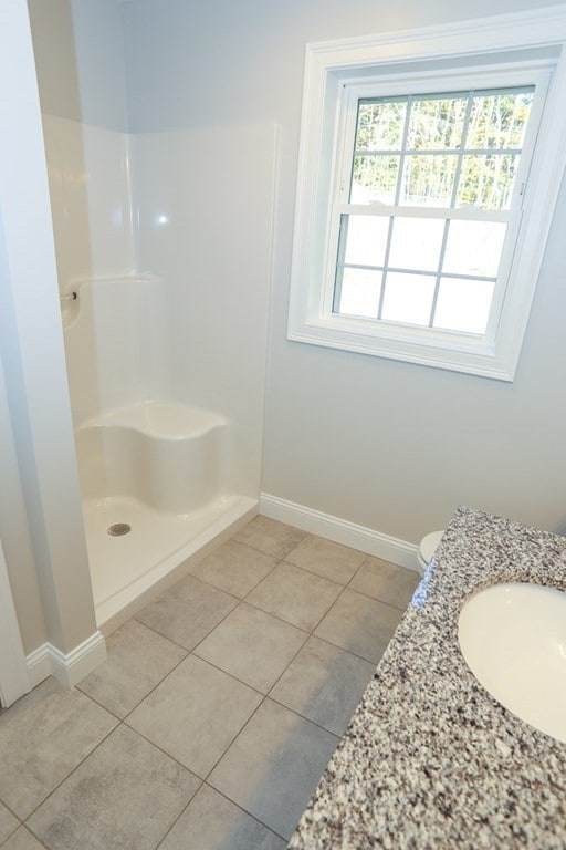 bathroom with tile patterned floors, vanity, and walk in shower