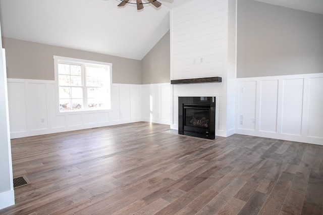 unfurnished living room featuring ceiling fan, dark wood-type flooring, and high vaulted ceiling