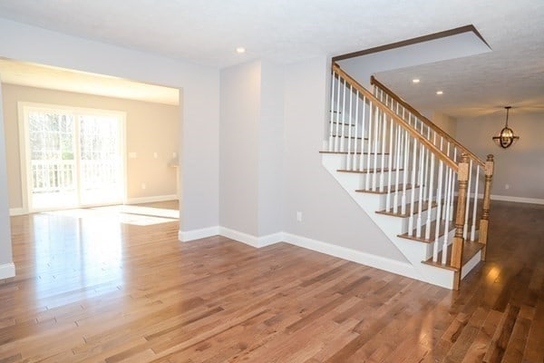 stairway with hardwood / wood-style flooring and an inviting chandelier