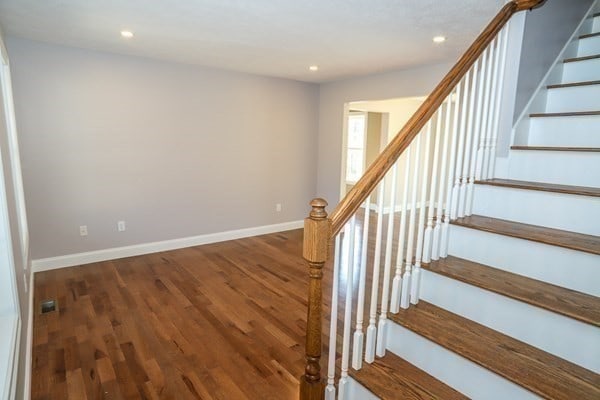 stairway with hardwood / wood-style floors