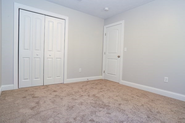 unfurnished bedroom with carpet flooring and a closet