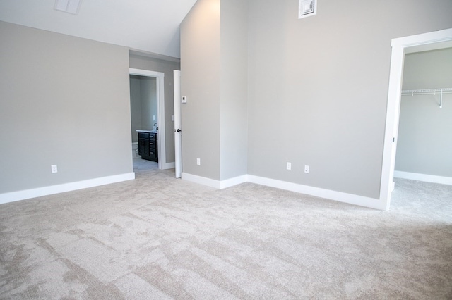 unfurnished bedroom featuring light colored carpet and a closet