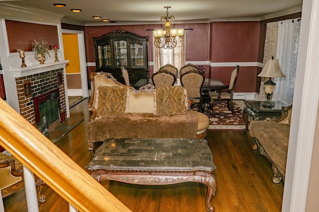 dining area with dark hardwood / wood-style floors, an inviting chandelier, crown molding, and a brick fireplace