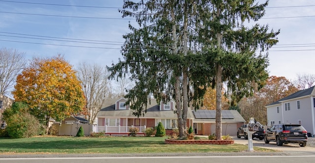 view of front of house with solar panels and a front lawn