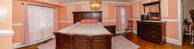 interior space with dark hardwood / wood-style floors, crown molding, and a baseboard radiator