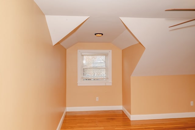 additional living space with light hardwood / wood-style floors and lofted ceiling