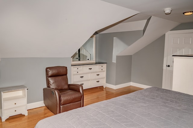 bedroom with light hardwood / wood-style floors and lofted ceiling