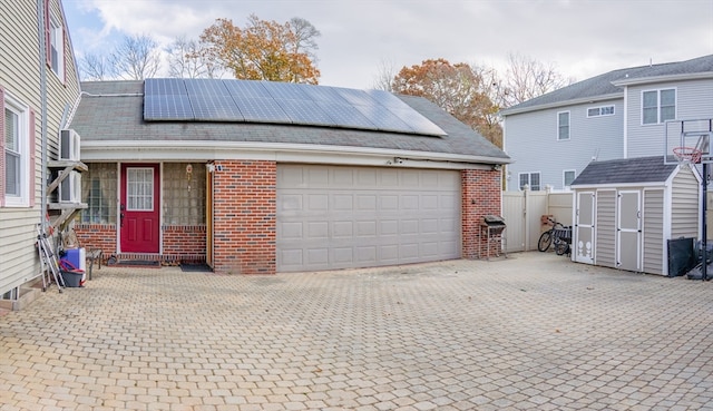 exterior space with solar panels, a garage, and a storage shed