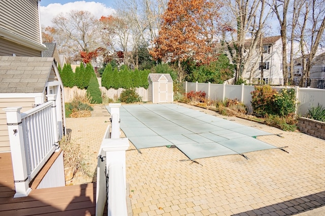 view of swimming pool with a patio area and a shed