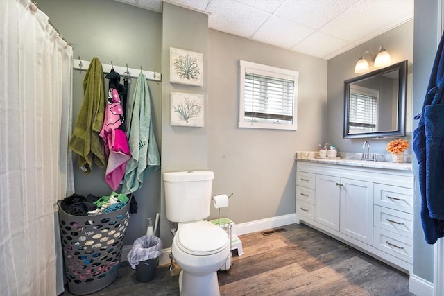 full bath featuring visible vents, wood finished floors, baseboards, vanity, and toilet
