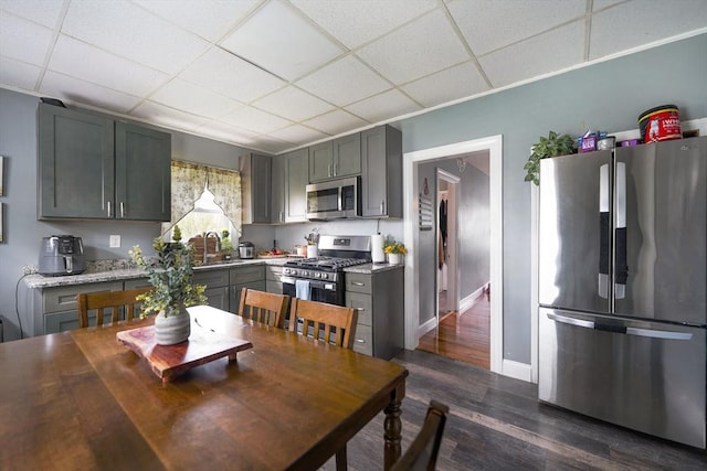 kitchen with gray cabinetry, appliances with stainless steel finishes, and a paneled ceiling