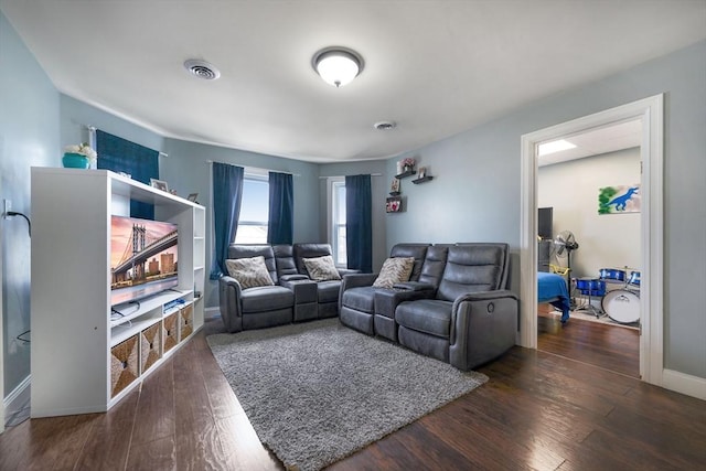 living room with baseboards, wood finished floors, and visible vents