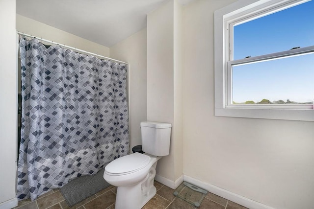 bathroom with baseboards, a shower with shower curtain, and toilet