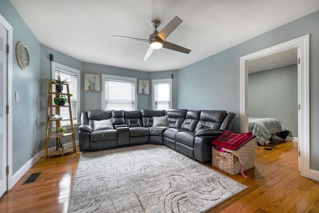living area with plenty of natural light, ceiling fan, light wood-type flooring, and visible vents