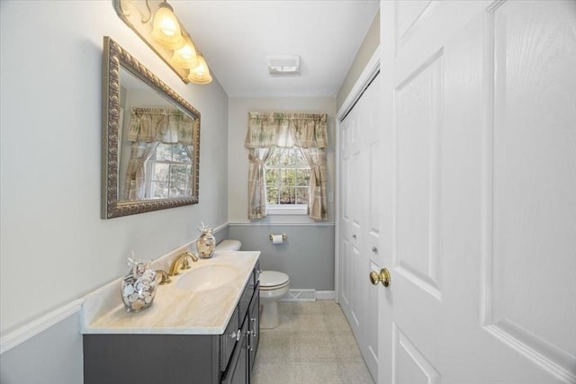 bathroom with vanity, baseboards, tile patterned floors, and toilet