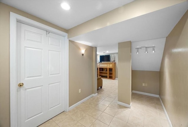 finished below grade area with baseboards and light tile patterned floors