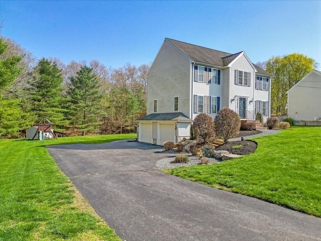 view of home's exterior featuring a yard, an attached garage, and aphalt driveway