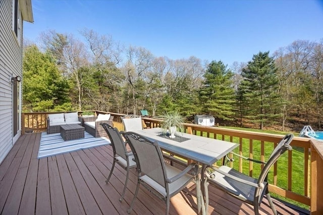 wooden terrace with outdoor dining area, an outdoor structure, a storage shed, and an outdoor hangout area
