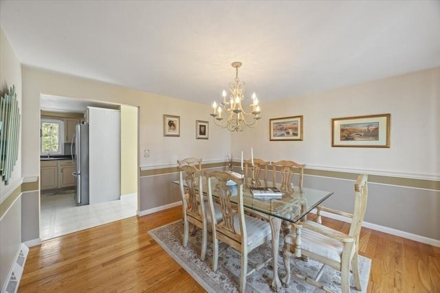dining area featuring an inviting chandelier and light wood-style floors