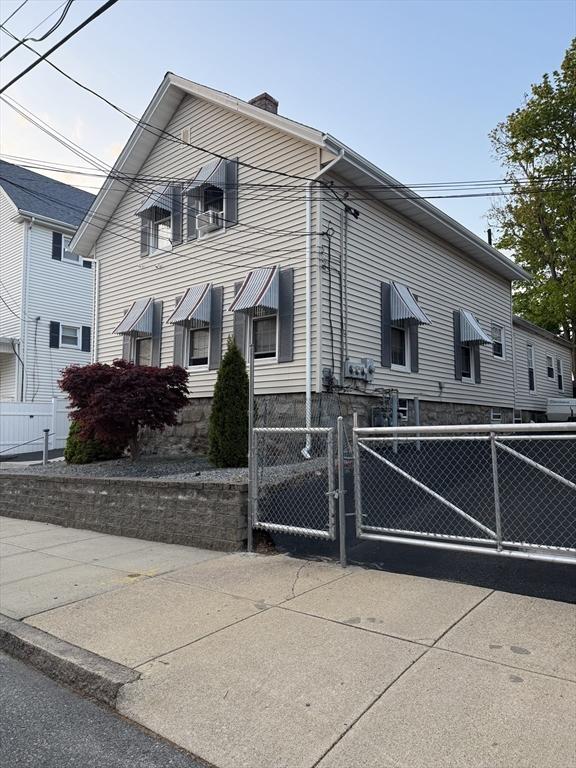 808 Walnut St, Fall River, MA 02720 - view of side of property with a chimney, fence, and a gate