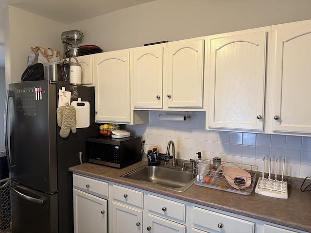 808 Walnut St, Fall River, MA 02720 - kitchen featuring dark countertops, appliances with stainless steel finishes, decorative backsplash, and a sink