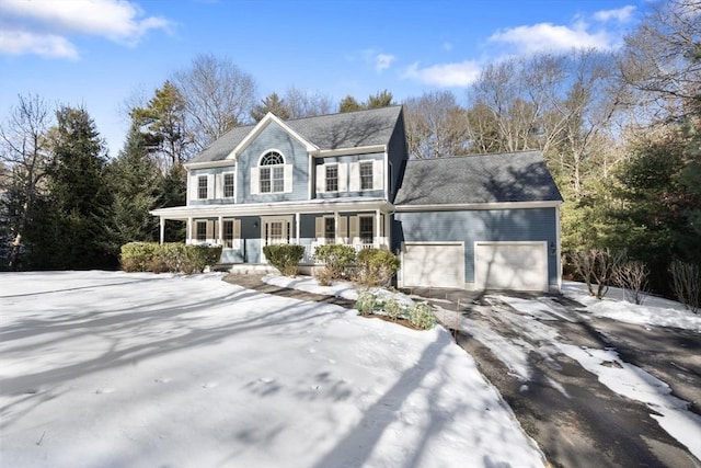 colonial-style house featuring a garage, covered porch, and driveway