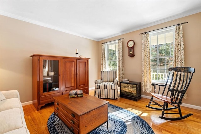 living room with crown molding, baseboards, and light wood finished floors