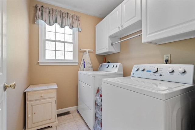 laundry room featuring baseboards, visible vents, washing machine and clothes dryer, light tile patterned flooring, and cabinet space